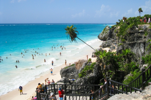 Crédito da foto: Foto de Math: https://www.pexels.com/pt-br/foto/pessoas-no-penhasco-com-arvores-de-grama-observando-as-pessoas-na-costa-do-mar-nadando-sob-nuvens-azuis-durante-o-dia-90947/ Tulum
